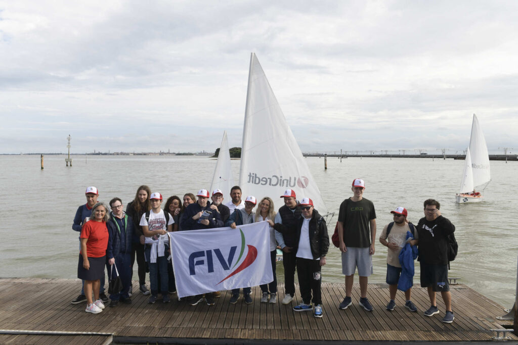 Foto di gruppo con lo striscione FIV sul pontile di Punta San Giuliano durante Navigare Insieme
